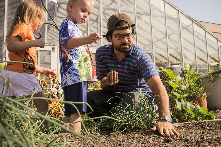 Doctoral student and children planting seeds