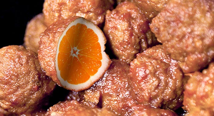 Illustration of meatballs with one cut open reveling an orange center