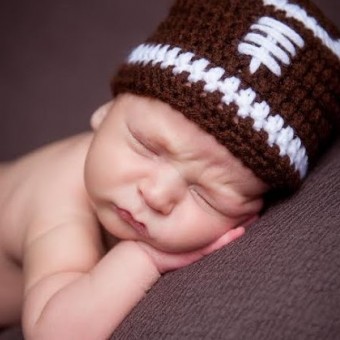 Baby with a football hat on