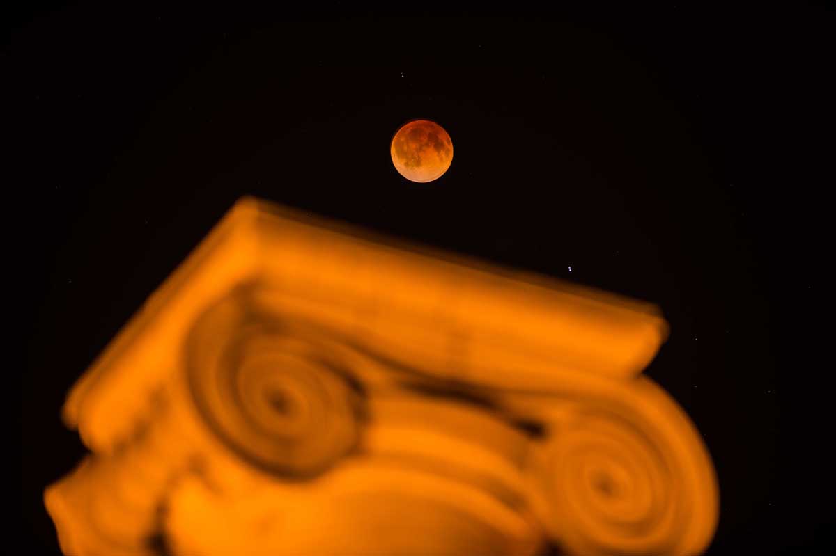 Light from the sun refracts through Earth's atmosphere to cast a brownish-red hue on the moon, known as a "blood moon."