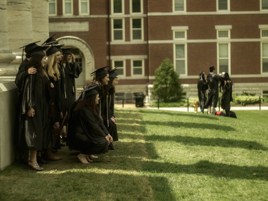 Students in caps and gowns by Columns