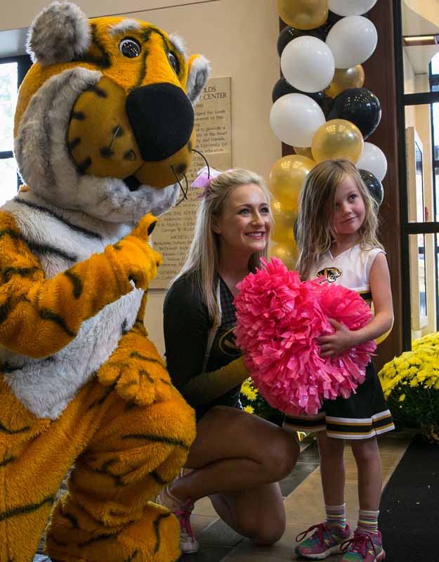 Truman poses for a photo with an MU cheerleader and an adoring fan.