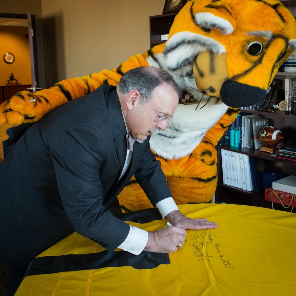 Chancellor Loftin and Truman the Tiger sign the 175th anniversary flag.