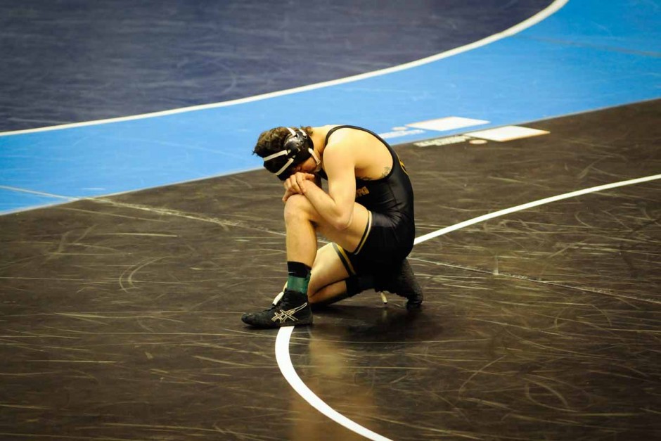 Sophomore Joey Lavallee kneels to the mat before his 8-6 win against Oklahoma's Justin DeAngelis in the 157-pound weight class.