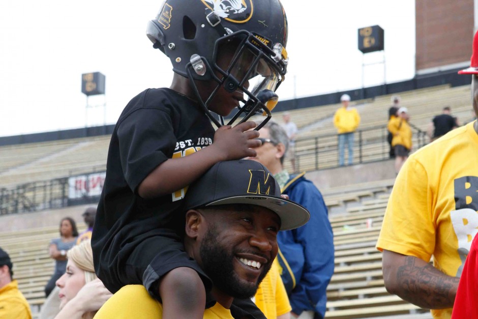 George Penton III sits on his father, George Penton III's, shoulders after the conclusiong of the spring game. Penton III tried on his older brother's helmet for size.