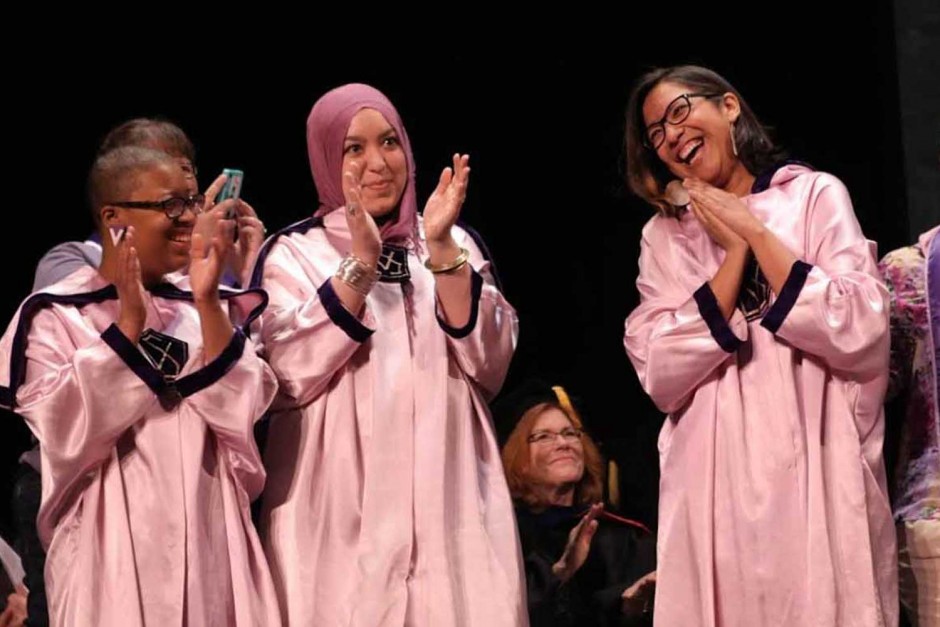 Girls in robes clapping.