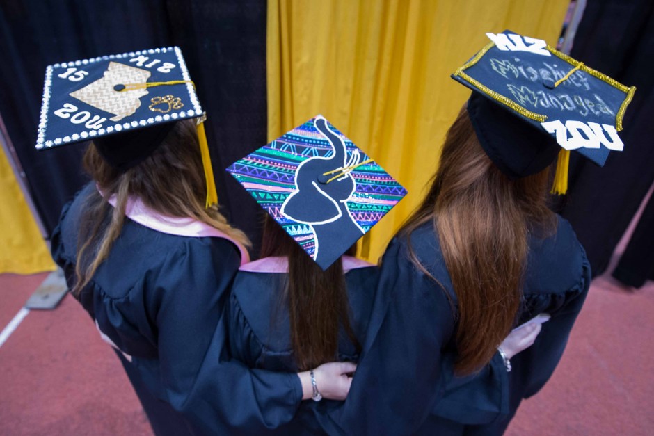 Three College of Agriculture, Food and Natural Resources (CAFNR) to-be graduates show off their caps.