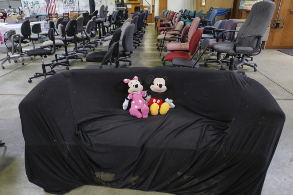 Minnie Mouse and Mickey Mouse cuddle together on a covered couch next to rows of office chairs in Mizzou's Surplus Property warehouse Wednesday, May 20, 2015. The dolls, couch and chairs will all be up for purchase at the Tiger Treasures Rummage Sale on Saturday, May 30 between 6:00 a.m. and 11:00 a.m.