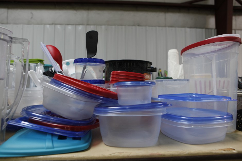 Tupperware, along with pots, pans, silverware and other kitchen utensils are stacked on another table in Mizzou's surplus property warehouse, Wednesday, May 20, 2015. Some pots were marked as low as $3.00 for the Tiger Treasures Rummage Sale, which will be held Saturday, May 30, 2015.