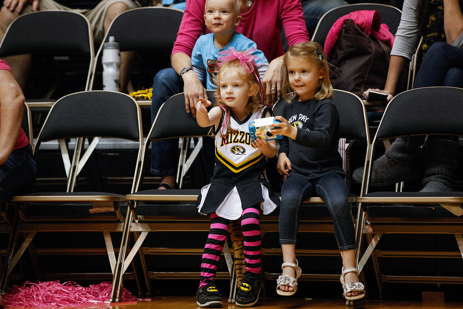 Annabelle Nelson, 4, and Summer Smith, 4, take photos and discuss the game courtside during the third set.