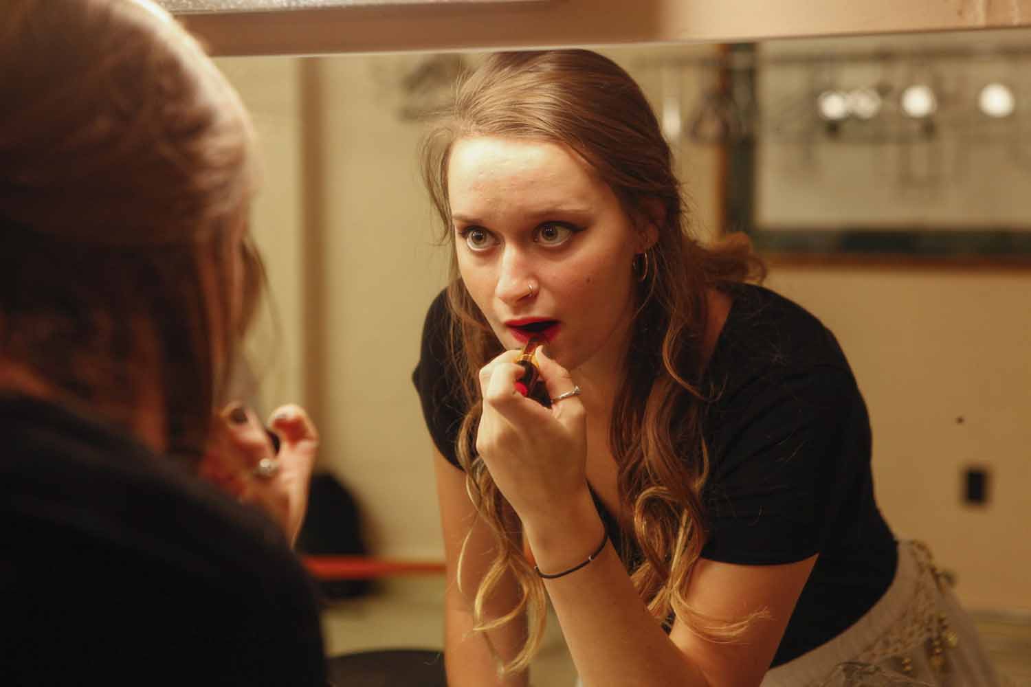 Paige Kiehl puts on lipstick in the mirror as she gets ready to perform with her group, Mizzou Masti, as part of India Nite at Jesse Hall.