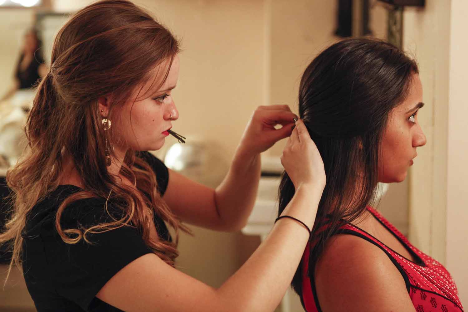 Paige Kiehl helps fellow Mizzou Masti member Sumidha Katti pin her hair back in the dressing room before their performance during the second act of India Nite at Jesse Hall.