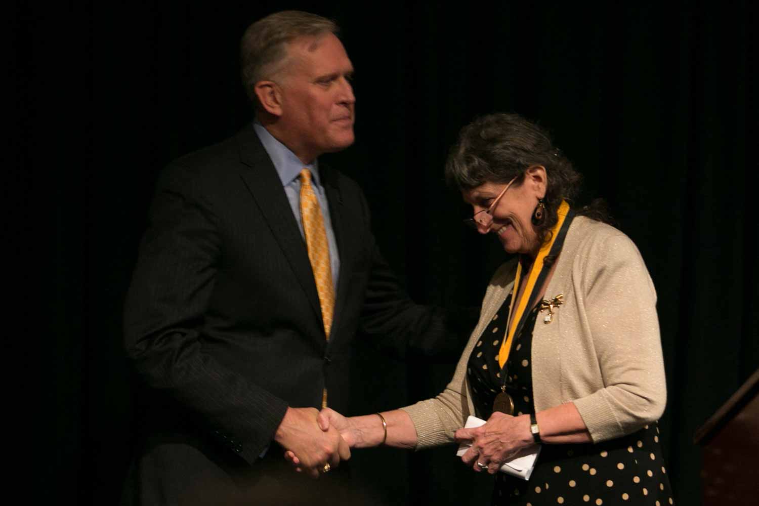 Merrill Perlman shakes Dean David Kurpius's hand after receiving her honor medal. In 1983, Perlman was hired as a Business copy editor at The New York Times, later becoming Metro copy desk chief (twice), night Metro editor, an editor on the Week in Review, recruiting editor for copy desks and managing editor of The New York Times News Service. In 2004, she was named director of copy desks, in charge of the 160-plus copy editors across the newsroom.