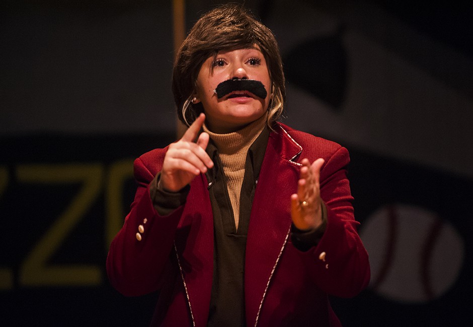 A performer dressed as Ron Burgundy acts out a skit