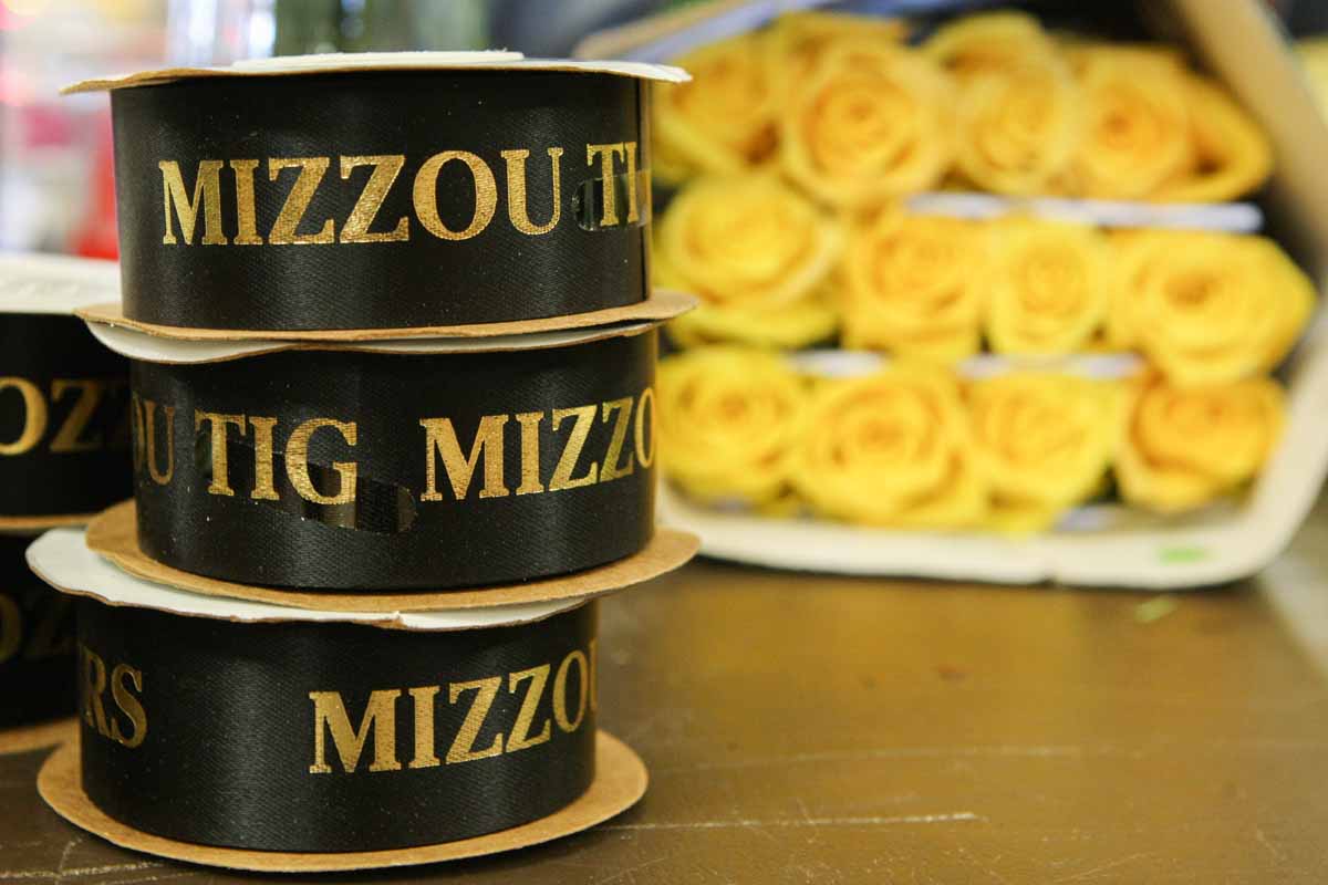 "Mizzou Tigers'' ribbon sits on a table accompanied by yellow roses in the foyer of Jesse Hall as College of Agriculture, Food and Natural Resources soon-to-be-graduates check in on the second floor Friday afternoon. The Mizzou SAIFD (Student American Institute of Floral Designers) sold bouquets of flowers to family members and friends to raise money for their organization.