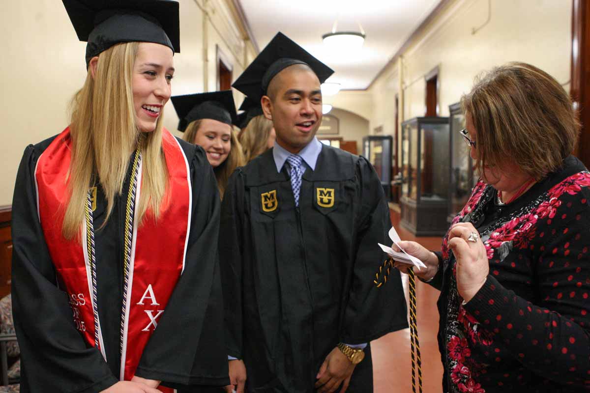 Jill Rechtien laughs with Tammy Conrad, an academic advisor for nutrition and exercise phisiology, as Conrad makes sure everyone in the NEP line is in the correct order before filing into Jesse Auditorium Friday afternoon.
