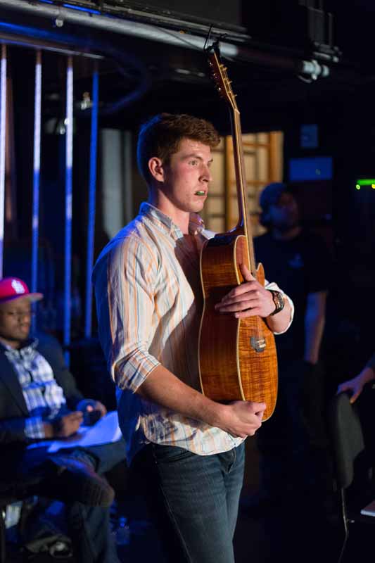 Mizzou Idol contestant Jared Carrier listens to critique from the judges just off stage while embracing his guitar. Photo by Jake Hamilton.