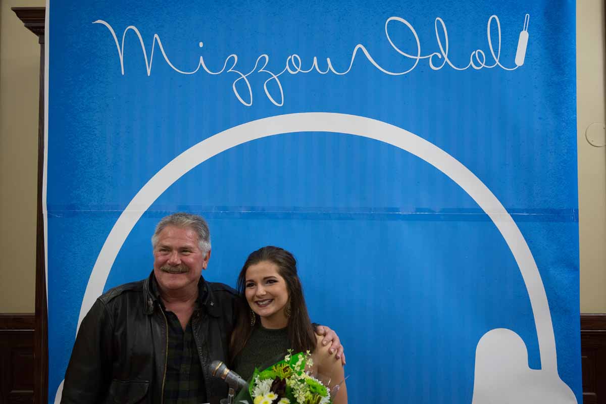Mizzou Idol winner Breanna Lehane poses with her father in front of the Mizzou Idol 2016 banner after the show. Photo by Jake Hamilton.