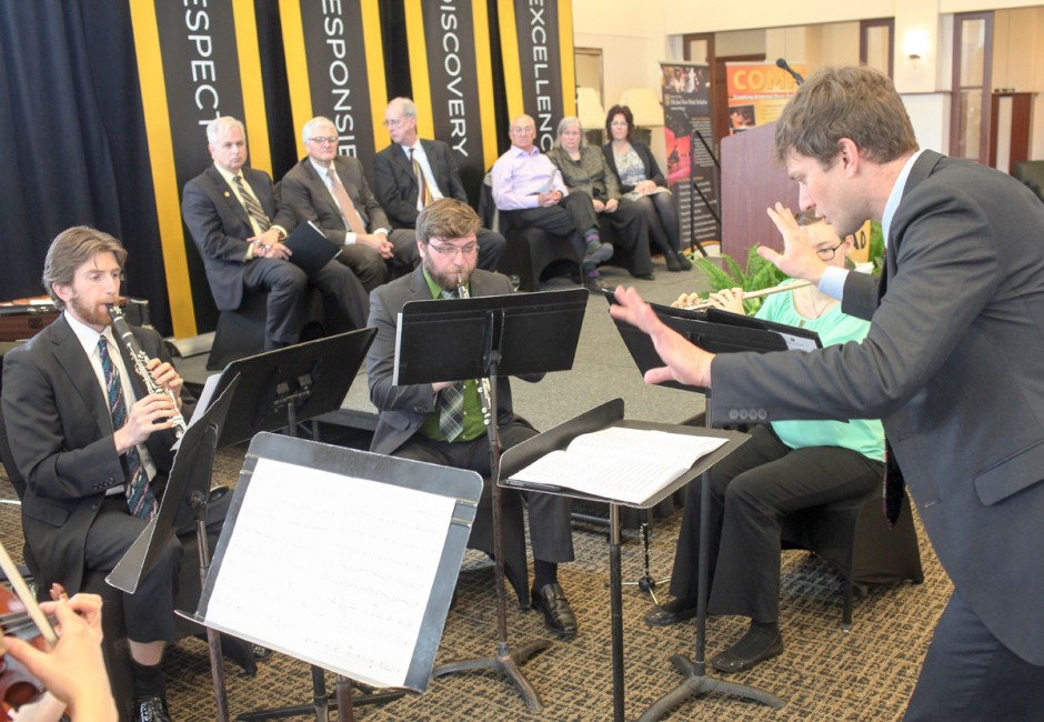 Musicians playing in front of administrators.