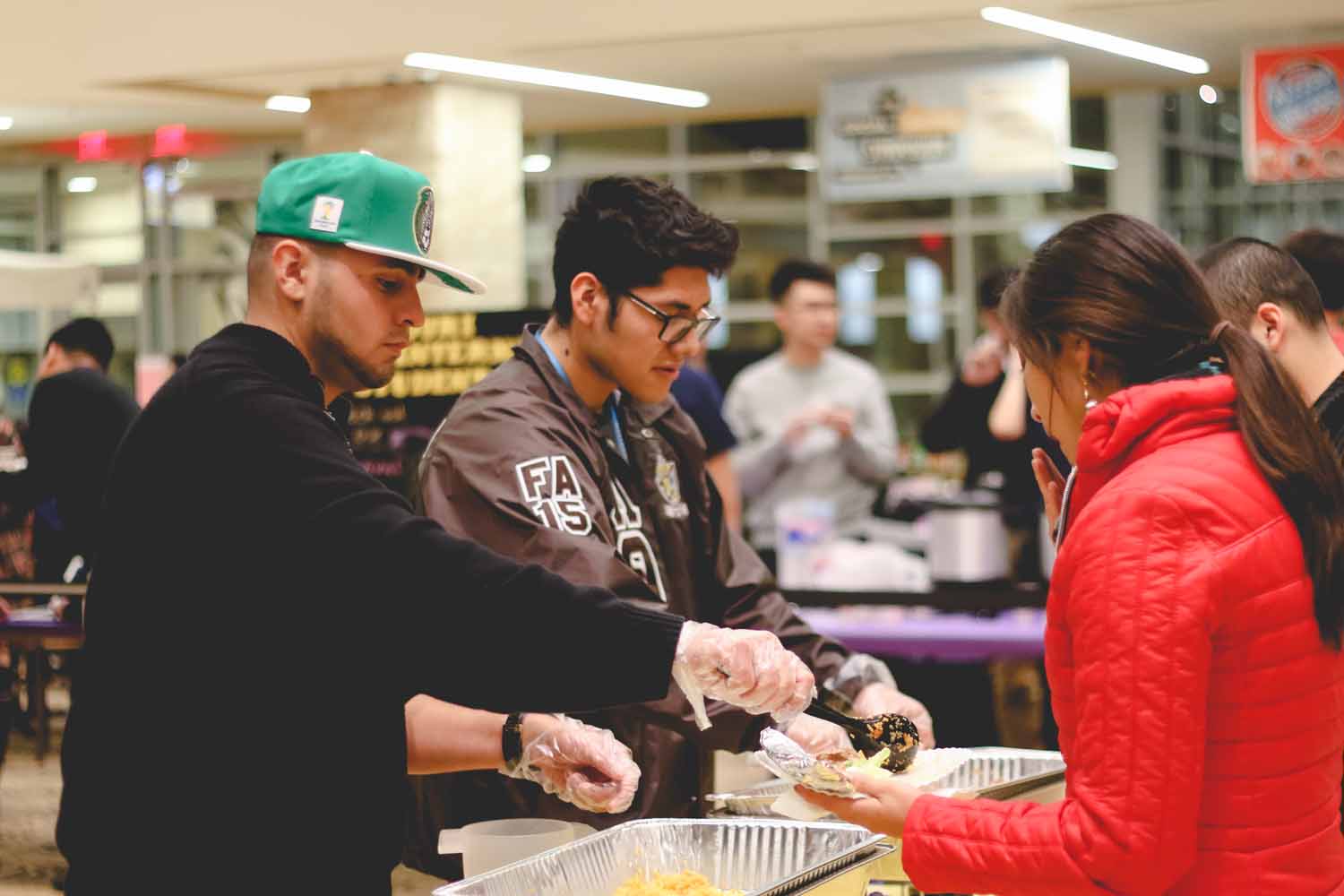 Members of Lambda Theta Pi, a Latin fraternity on campus, serve traditional dishes to attendees. Photo by Hanna Yowell.