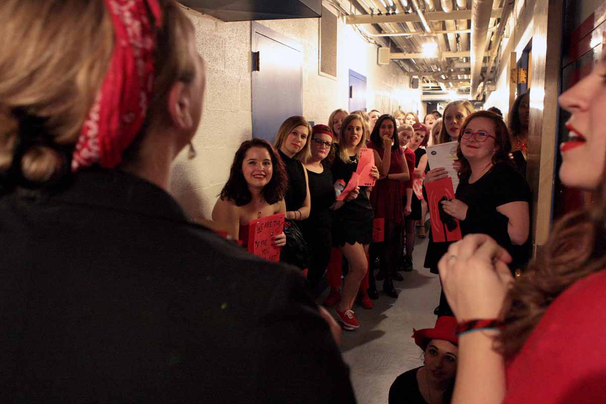 Kelsey Burns, one of three advisors for the Vagina Monologues, pep talks the actresses in the hallway below Jesse Auditorium's stage Saturday evening, Feb. 27, 2016 before the show.