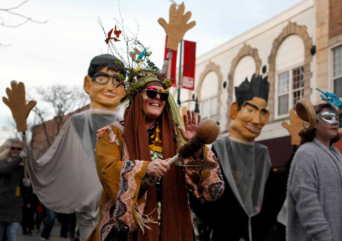 A parade attendee marches in front of caricatures of True False co-founders Paul Sturtz and David Wilson on Walnut Street. Photo by Tanzi Propst.