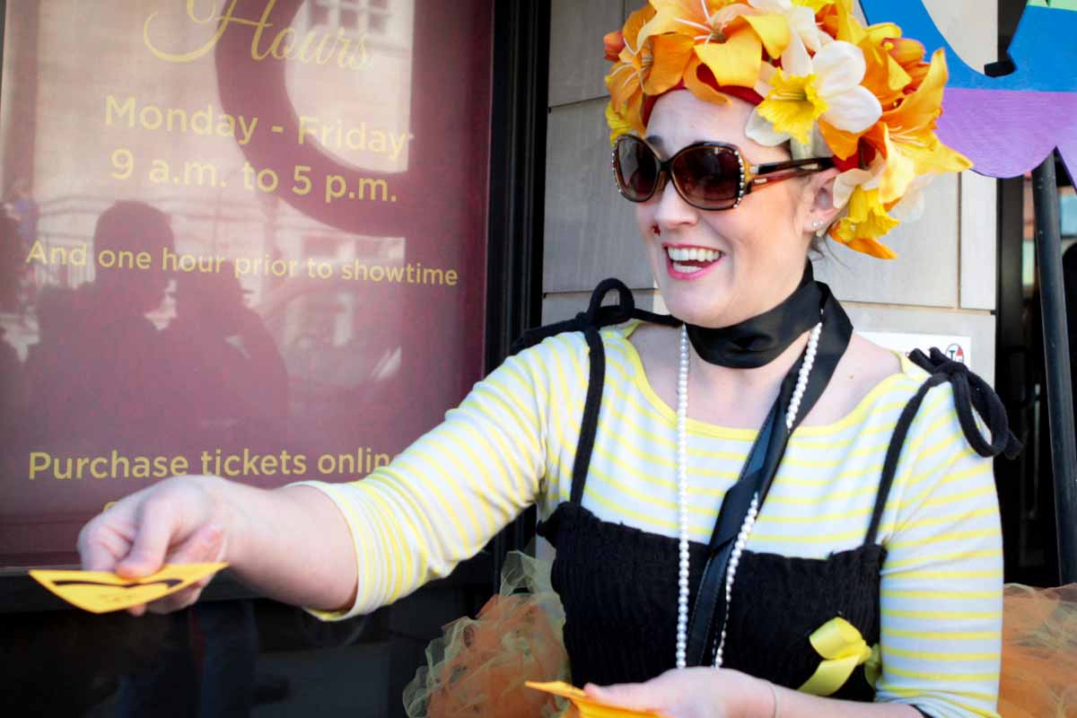 Volunteer Beth Hunter passes out Q cards outside of the Missouri Theatre for the 4 p.m. showing of Starless Dreams Saturday afternoon. Photo by Tanzi Propst.