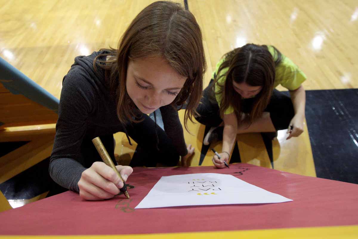 From left, Meg Adams and Amanda Moy, both sophomore recruitment leadership members and morale captains for MizzouThon, decorate a sign for the jail station during set up at the Mizzou Rec Center Friday evening. Dancers could get pulled from the dance floor during the main event by Miracle Children and get stuck in jail. They would then have to fundraise their way out.