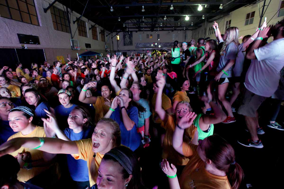 Dancers jump around together during Power Hour at MizzouThon. Leadership members and morale captains threw around glow sticks for dancers to make glasses, bracelets and necklaces out of.
