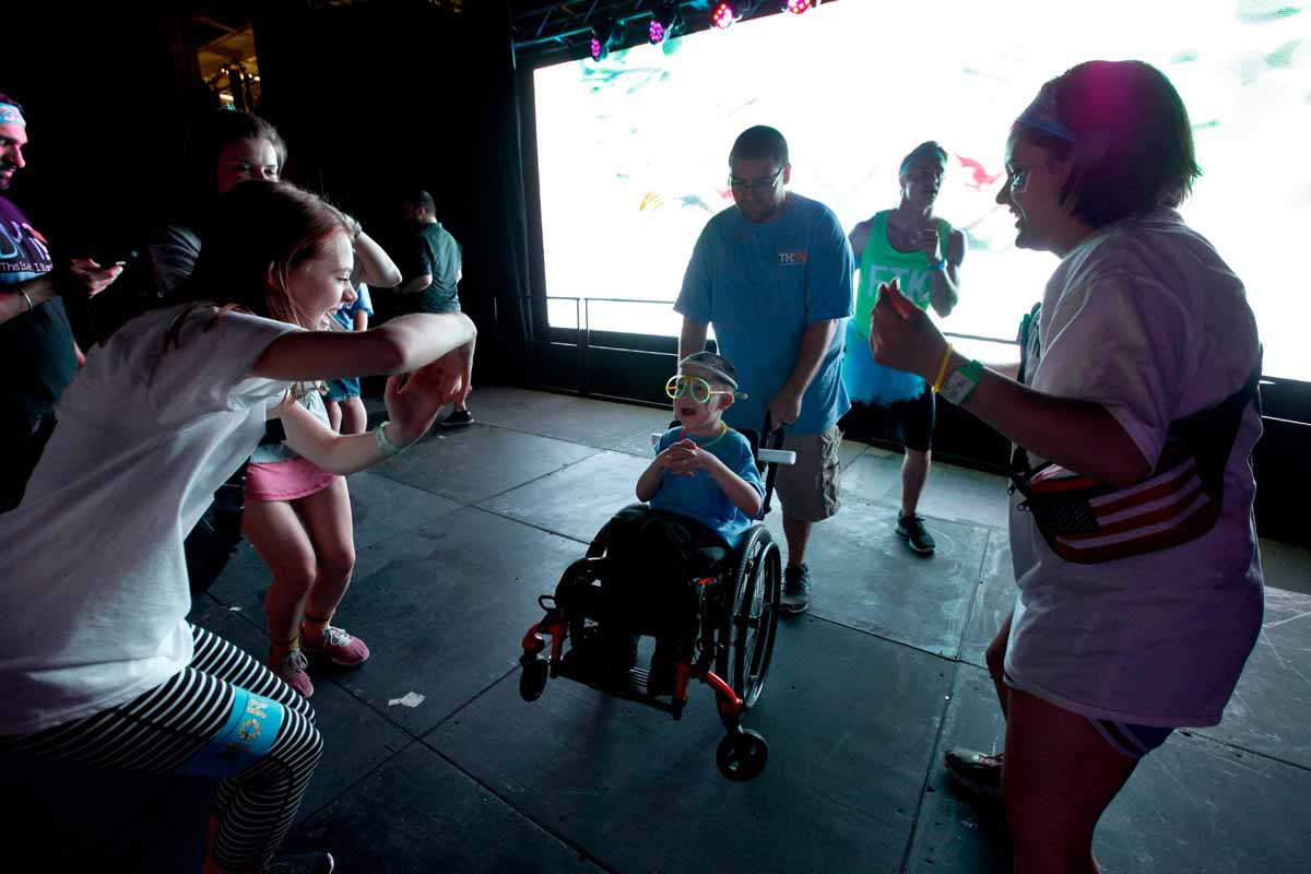 Declan Johnson, 8, dances with his dad and MizzouThon leadership members Leah Hoelscher and Ann Marie Metzendorf on stage near the end of Power Hour.