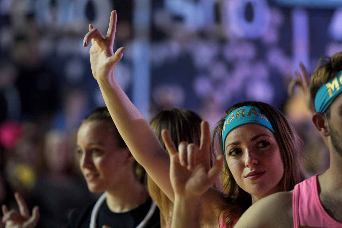 Alexis White raises her hand in the air with the sign language for "I love you" as Miracle Families cut wristbands off each dancer at the conclusion of the main event.