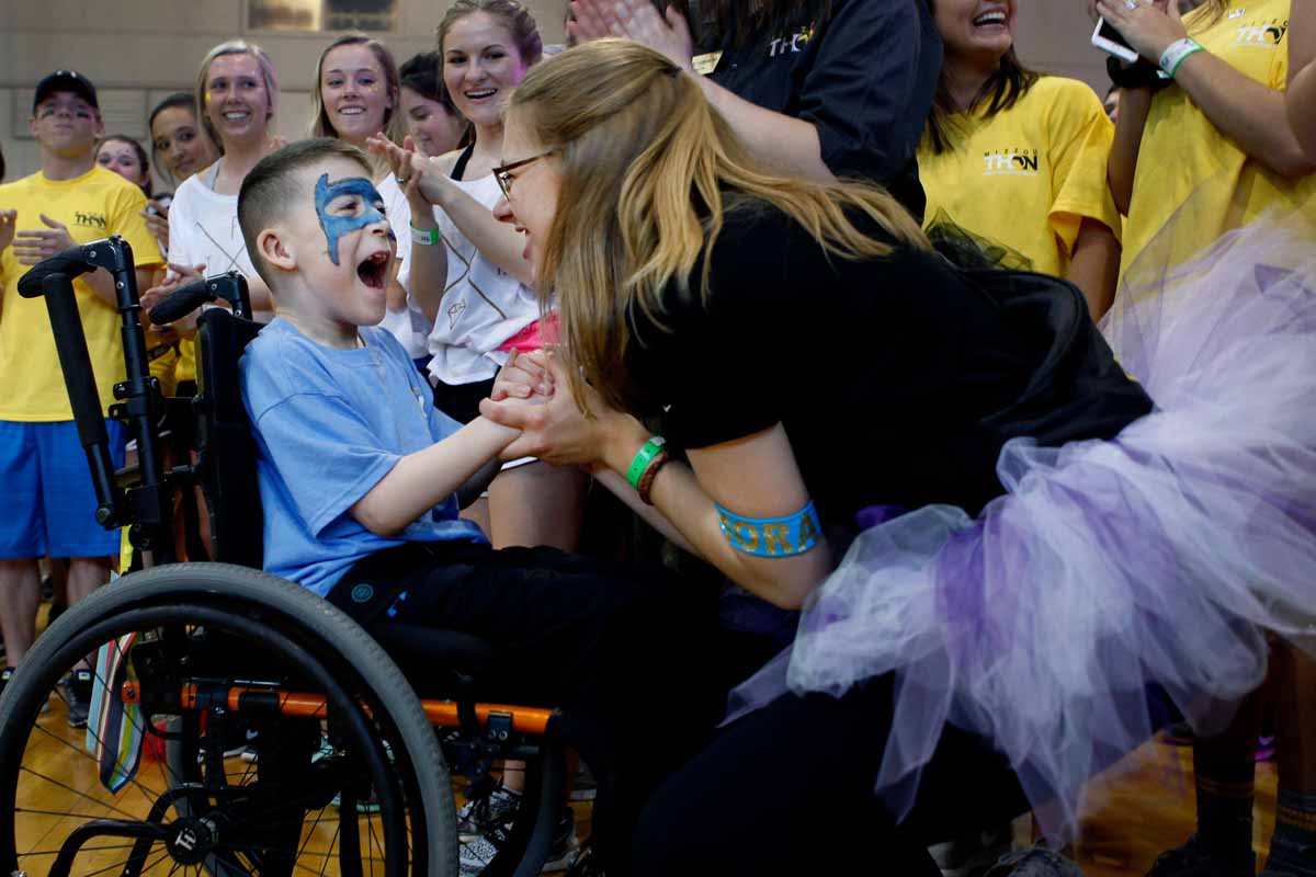 Sophomore Leah Hoelscher dances with one of MizzouThon’s Miracle Children, Declan Johnson, 9, in the middle of a cheering ring of dancers. Morale team members spend the 13.1 hours introducing the Miracle Families to dancers and boosting the dancers’ spirits.