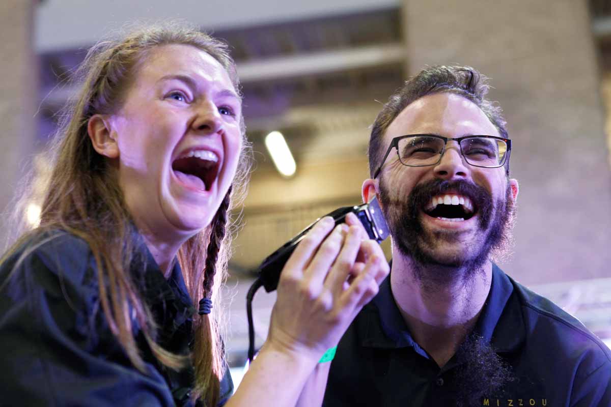 Senior Erin Ehlers, shaves her boyfriend Aaron Warning's beard during the main event Saturday, March 12, 2016. Warning had spent 10 months growing out his beard, claiming that if he raised over his $1,000 fundraising goal he would shave it off for the kids.