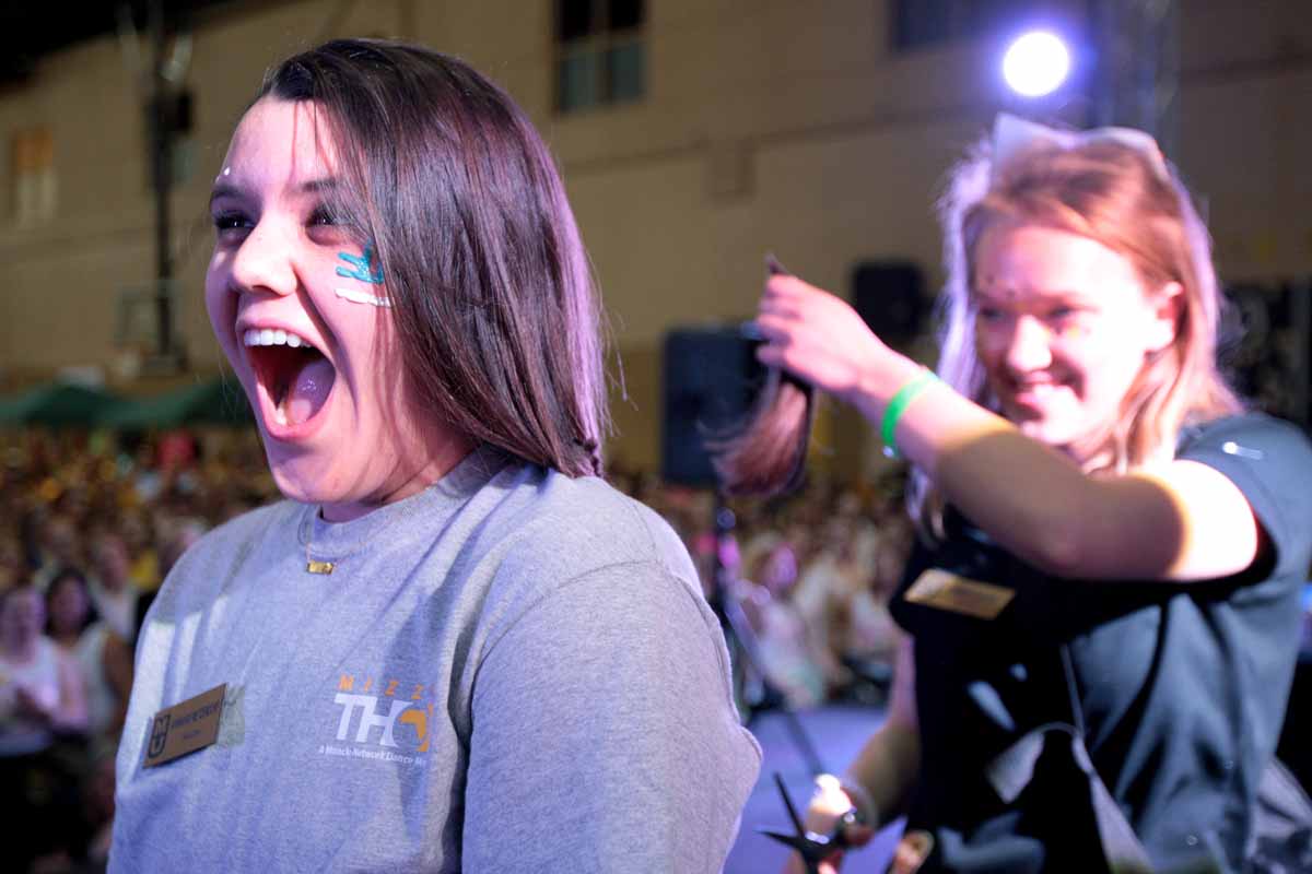Sophomore Ann Marie Metzendorf, internal recruitment leadership member and morale captain, has her hair cut by Sarah Godke during the main event Saturday evening.