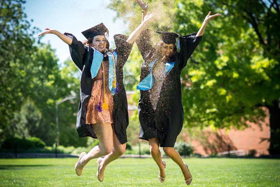 Marketing major Vanessa Salomon and communication major Holly Sias celebrate their impending graduation by jumping for joy with gold glitter. Photo by Shane Epping.