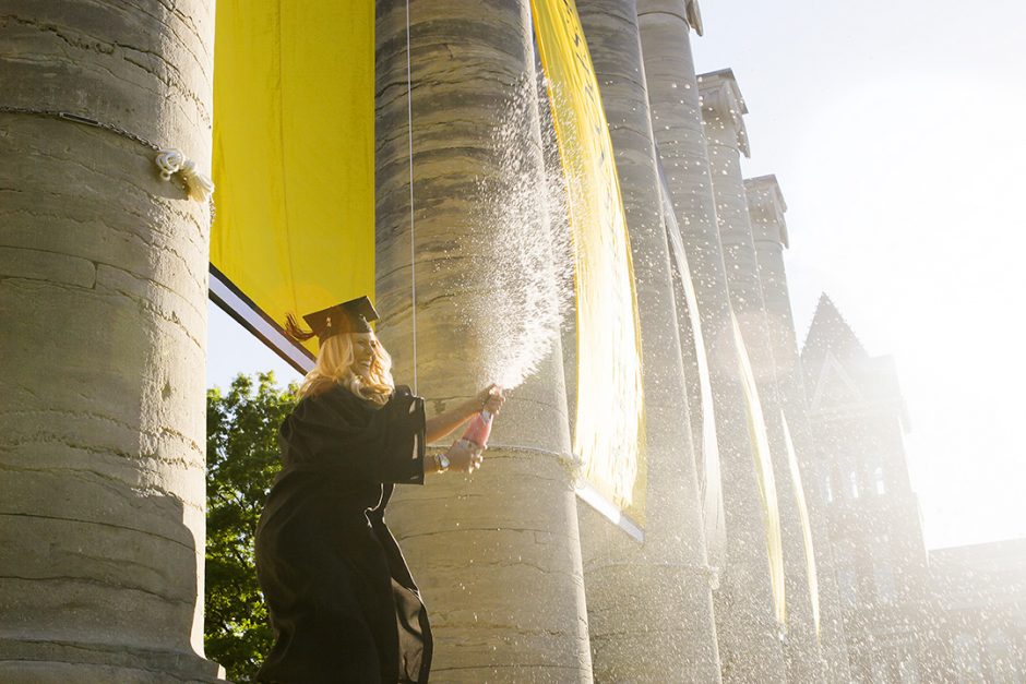 Taylor Gross, a 2016 textile and apparel management graduate from Sycamore, IL, sprays sparkling grape juice from the base of the columns. 