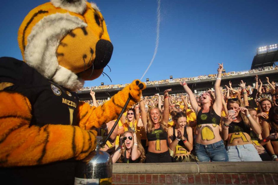 Tiger fans cheer as Truman the Tiger sprays water over the crowd before kickoff.
