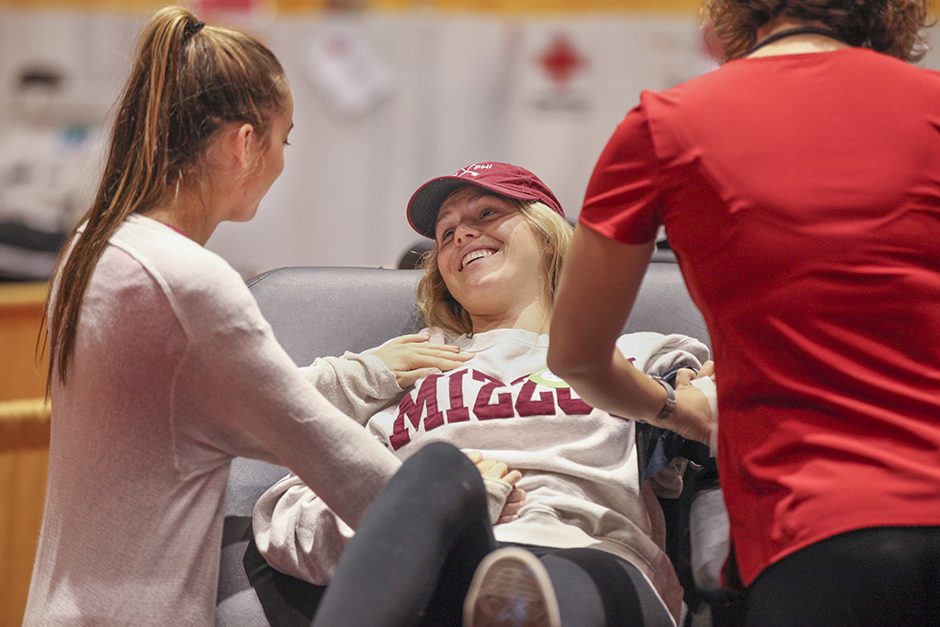 Kellen Renard is comforted by Emory McCloud, left, before she gives blood. After technicians were unable to locate a vein and Kellen did not give blood. Photo by Rob Hill