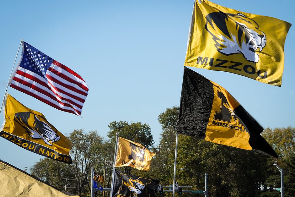 Mizzou and Ol’ Glory flags fly high on the north side of Stadium Boulevard where tailgaters populate a parking lot. Photo by Shane Epping.