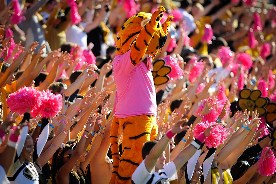 Truman and members of Tiger’s Lair raise their arms during the opening kickoff. Photo by Shane Epping.