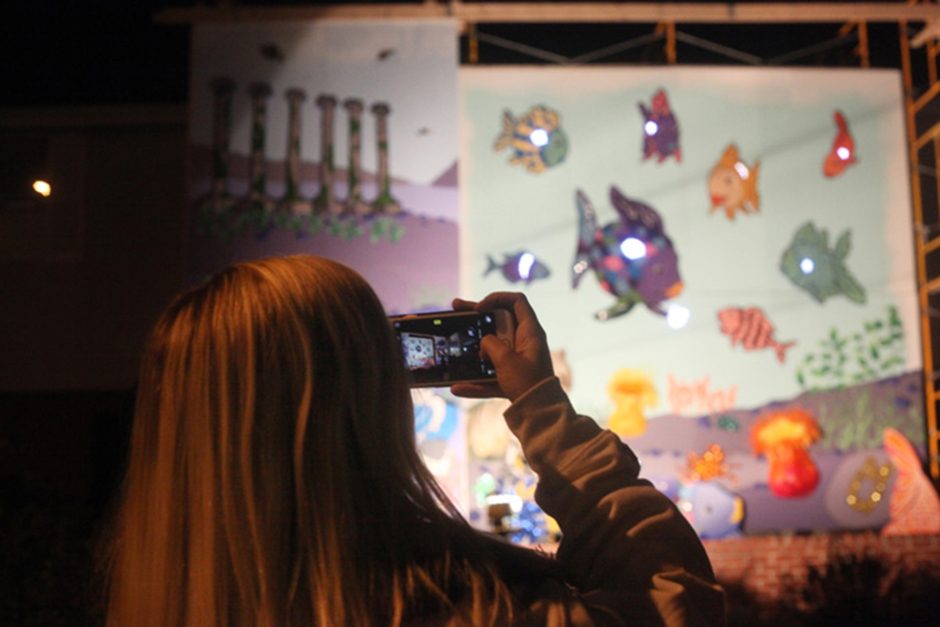 A woman takes a photo of the house decorations created by Sigma Kappa and Sigma Alpha Epsilon during the homecoming house decoration showcase on Friday, Oct. 22, 2016.