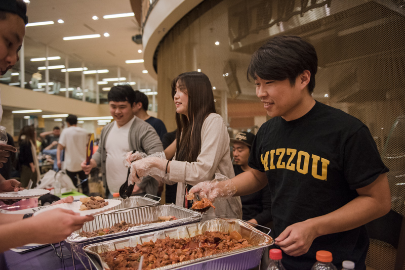 Students dishing out food for guests.