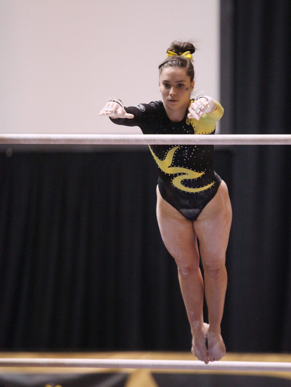 Gymnast peforming on uneven bars.
