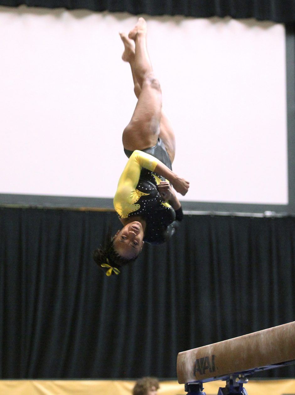 Gymnast spinning in the air upside-down.