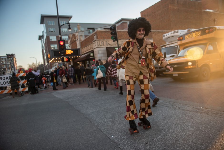 Guy in bell bottoms and an afro wig on roller skates.