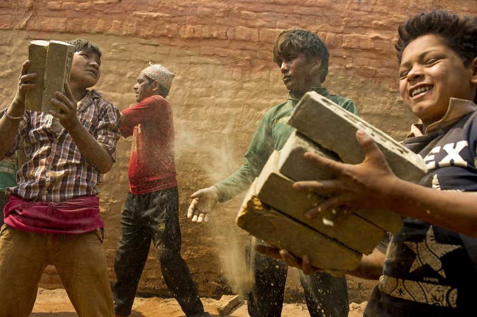 Young boys help stack bricks inside a kiln in Dhading district, Nepal in April, 2016.