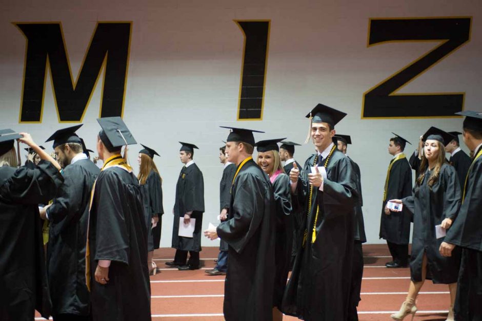 Students in caps and gowns walking together.