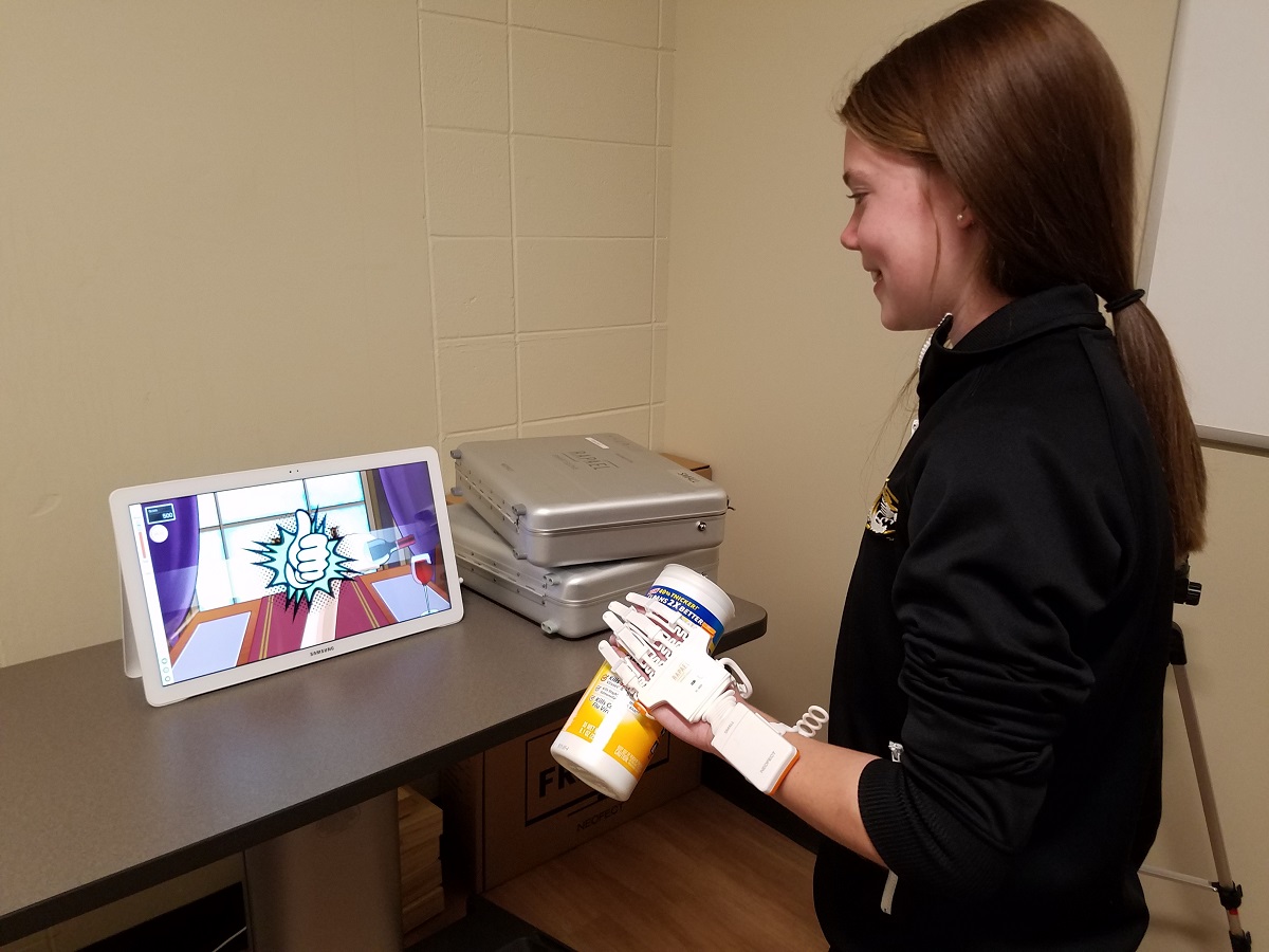 A middle school student uses the Rapael Smart Glove to replicate range of motion and therapy tasks used by occupational therapists and researchers treat patients and study various forms of therapy.
