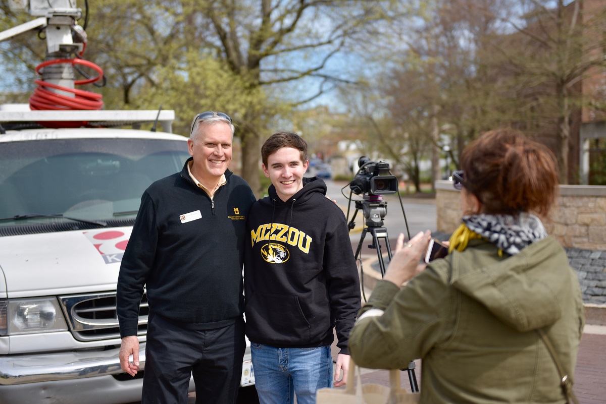 Matt McCabe, 18, of Overland Park, Kansas, poses for a photo with Dean David Kurpius outside the KOMU 8 live truck on the South Eighth Street circle. His mom, Susan, right, took the photo after the McCabe family visited the truck.