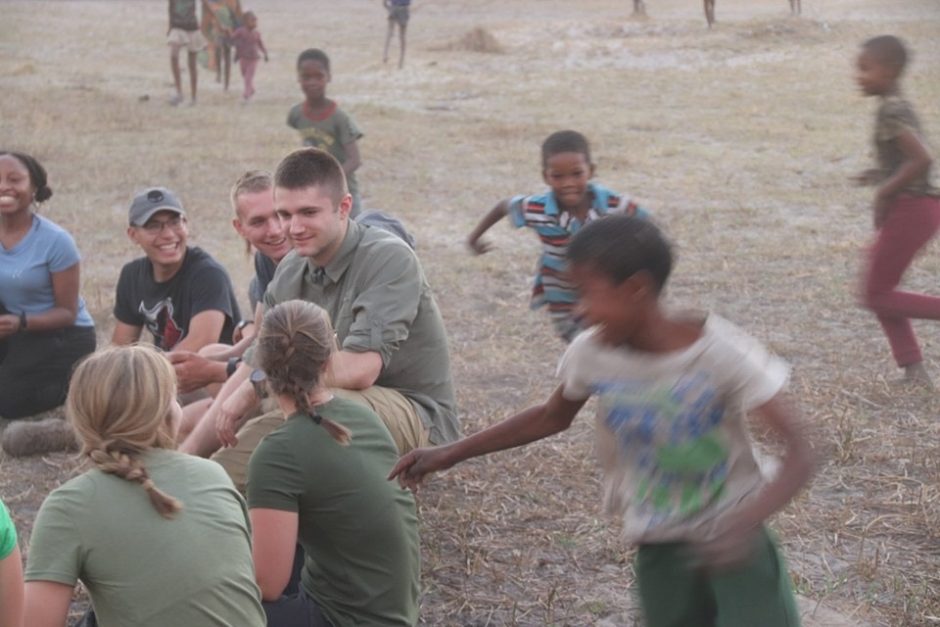 Benjamin Steger and his fellow cadets play duck-duck goose with children from an Botswanan tribe.